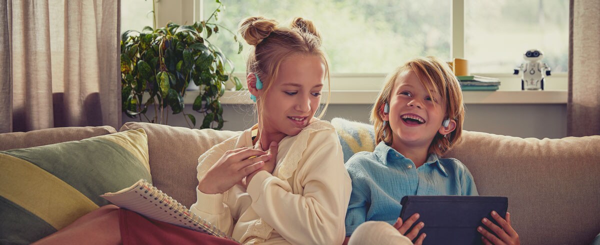 Vaikai džiaugiasi vaizdo įrašais, naudodami „Philips“ vaikiškas ausų neuždengiančias ausines
