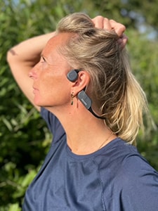 Moteris dėvi „Philips“ kaulų laidumo „Bluetooth“ ausines
