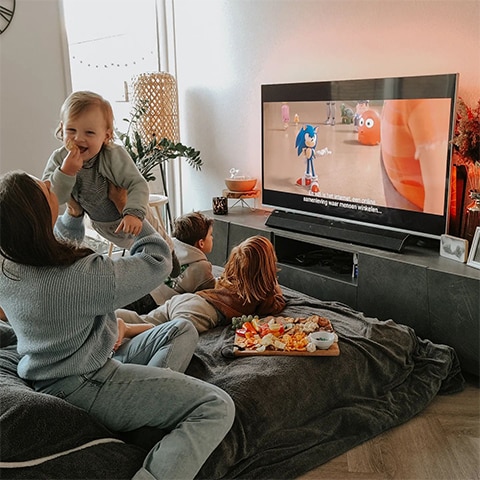 Ģimene skatās Ambilight TV